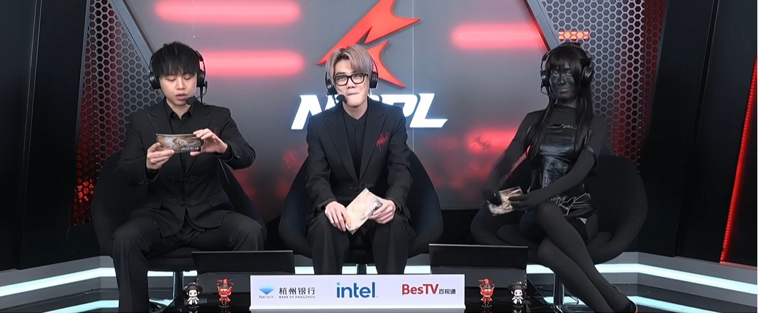 三位解说同台，右侧女性全身涂黑