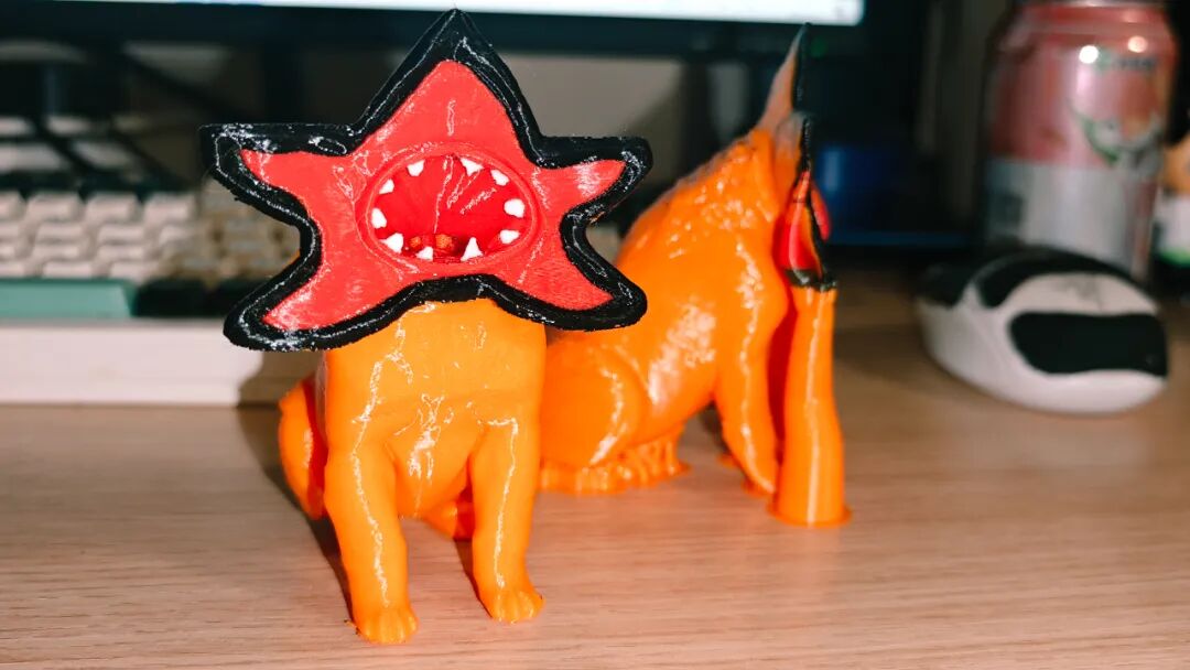 两个橙色的3D打印生物模型，其中一个戴有星形头盔