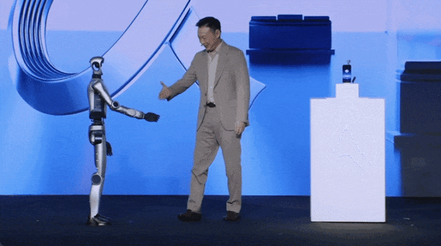 荣耀CEO李健在MWC现场与人形机器人新品握手