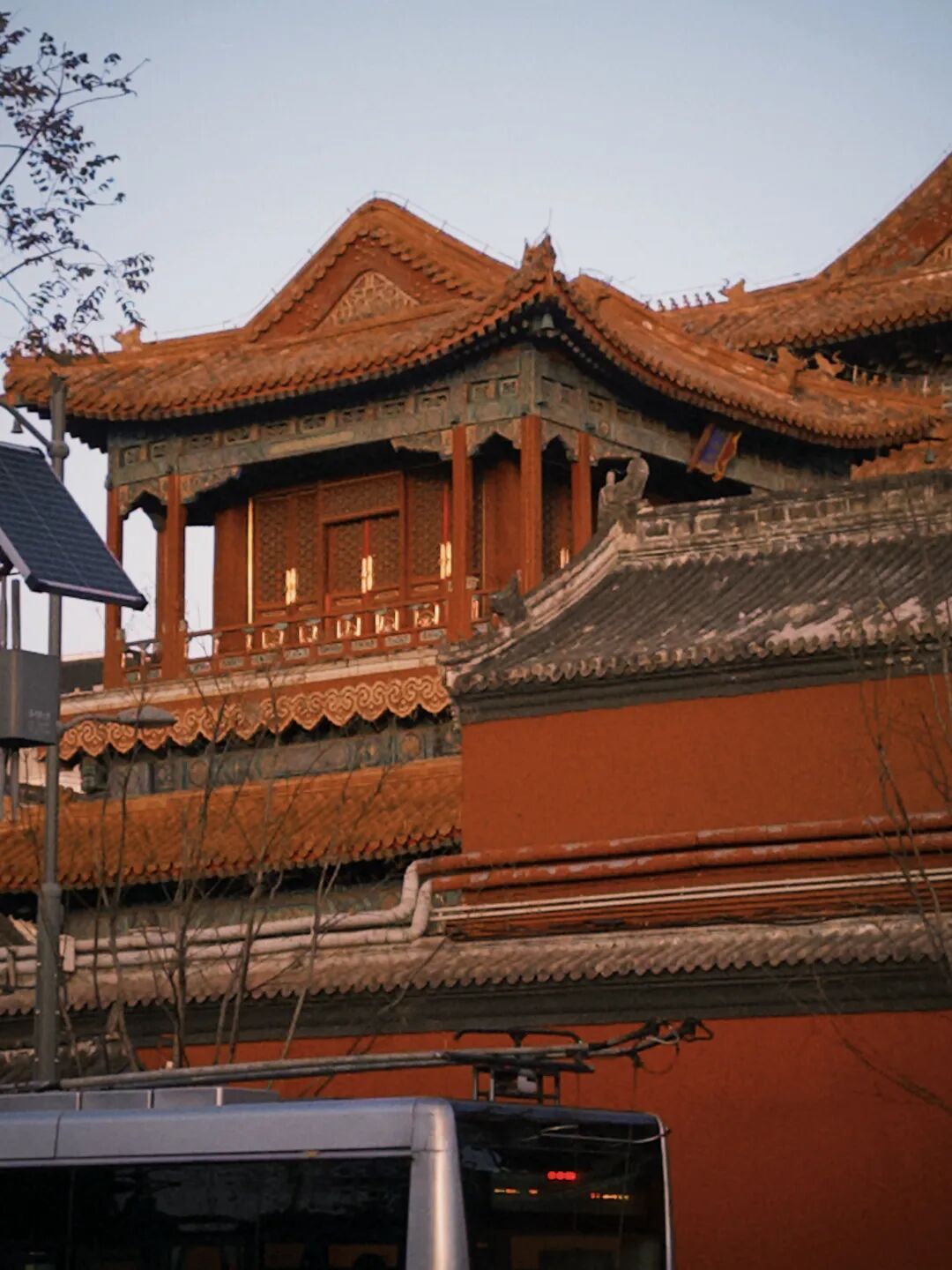 红墙金瓦的传统建筑与现代公交车