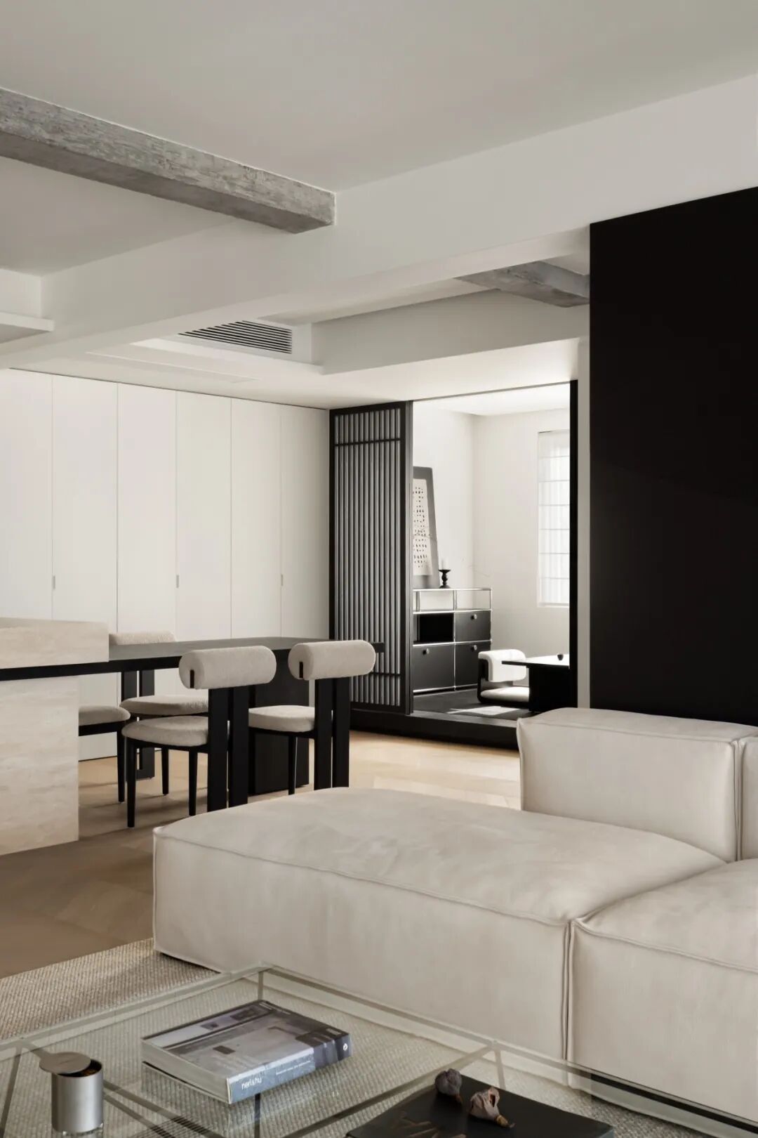 客厅沙发区与餐厅，黑色格栅隔断