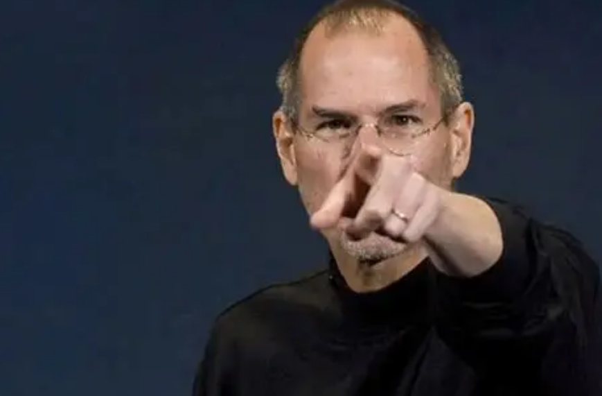 乔布斯照片，戴眼镜，身穿黑色高领衫，手指向前