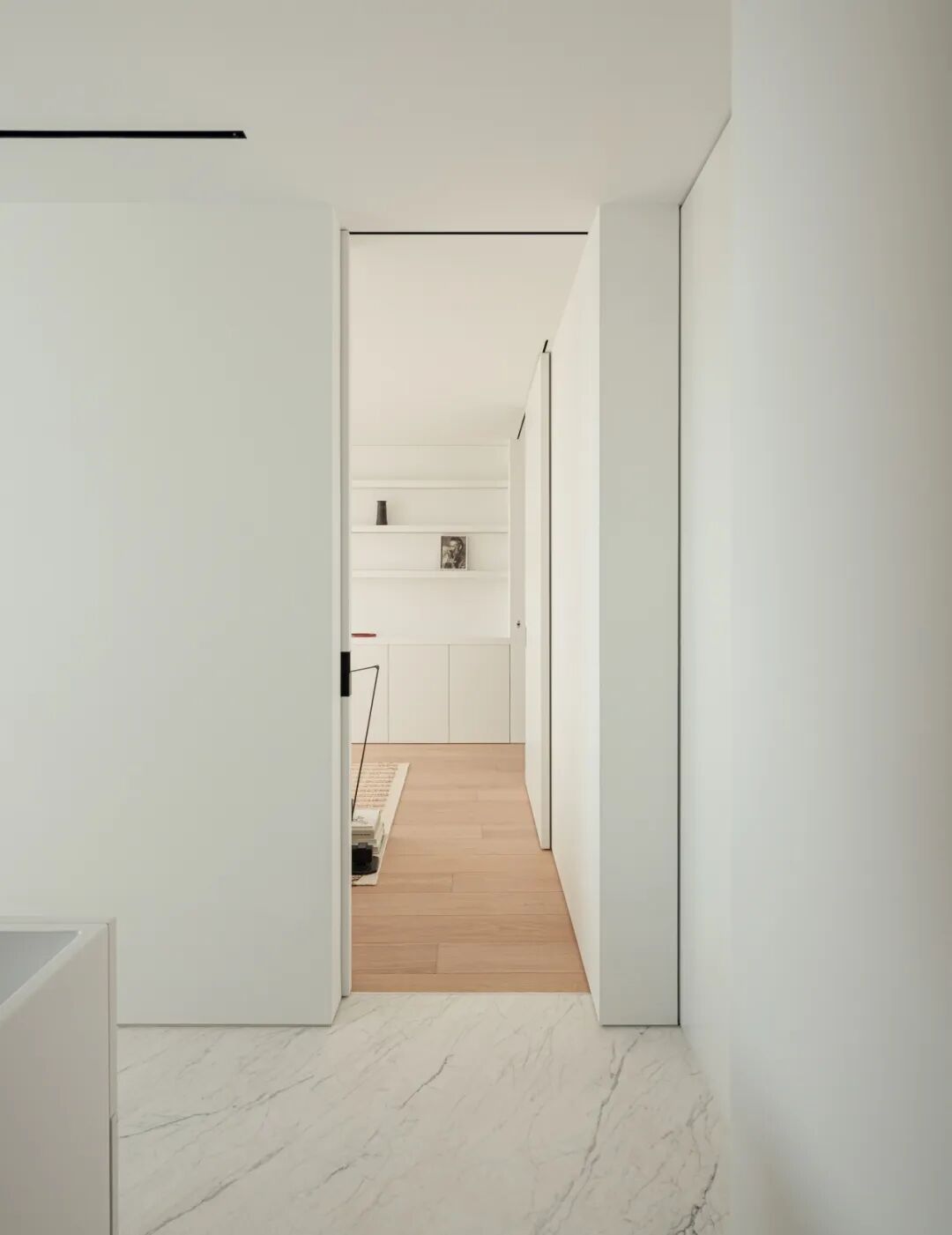 极简风格室内，白色推拉门与浅色地毯