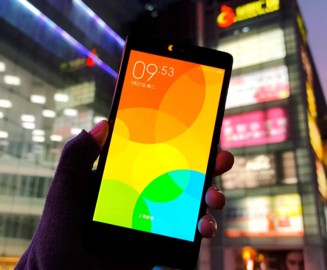 握在手中亮屏的红米Note，显示锁屏界面