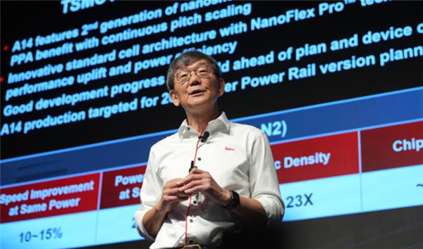 台积电高层在行业会议上发表演讲,身后屏幕展示A14制程技术参数与性能对比