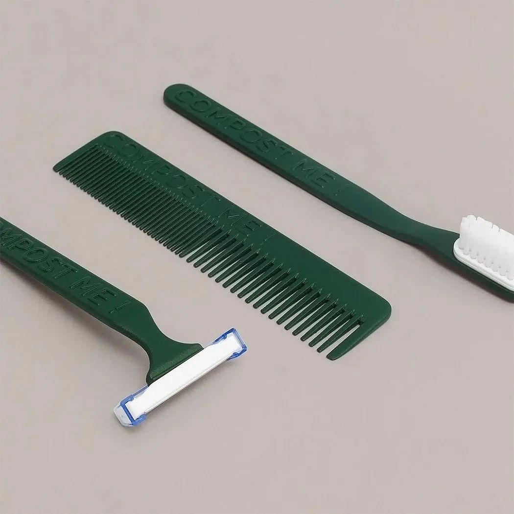 三件绿色塑料个人护理用品：梳子、剃须刀和牙刷