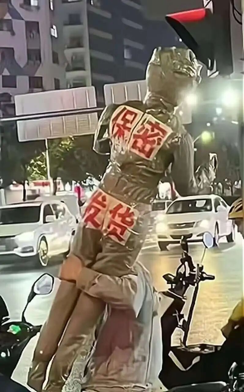 街头表演者背贴“保密发货”字样