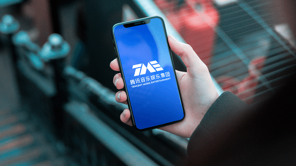 手持手机显示腾讯音乐娱乐集团LOGO