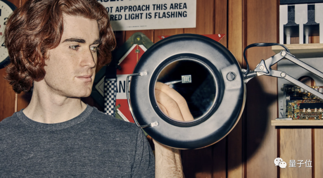 美国青年Sam Zeloof在放大镜下观察自制芯片