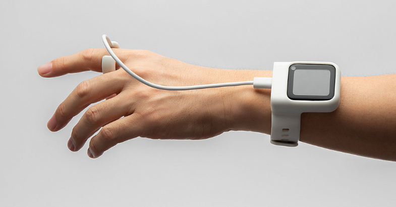 佩戴白色智能手表的手腕，连接着指尖传感器装置