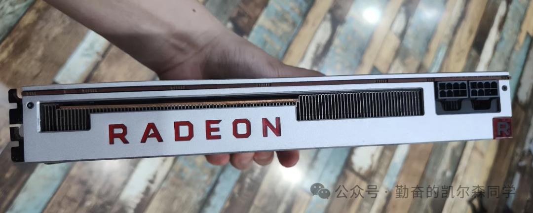 手持AMD Radeon VII显卡，展示其“RADEON”标志