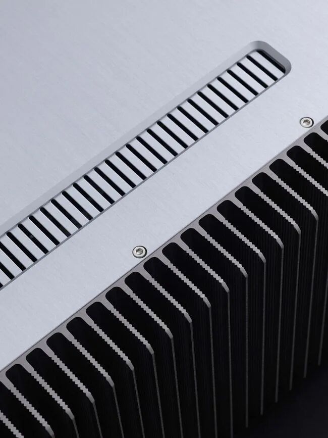 银灰色金属设备上的长条形横向散热格栅与大面积波浪状黑色散热鳍片特写