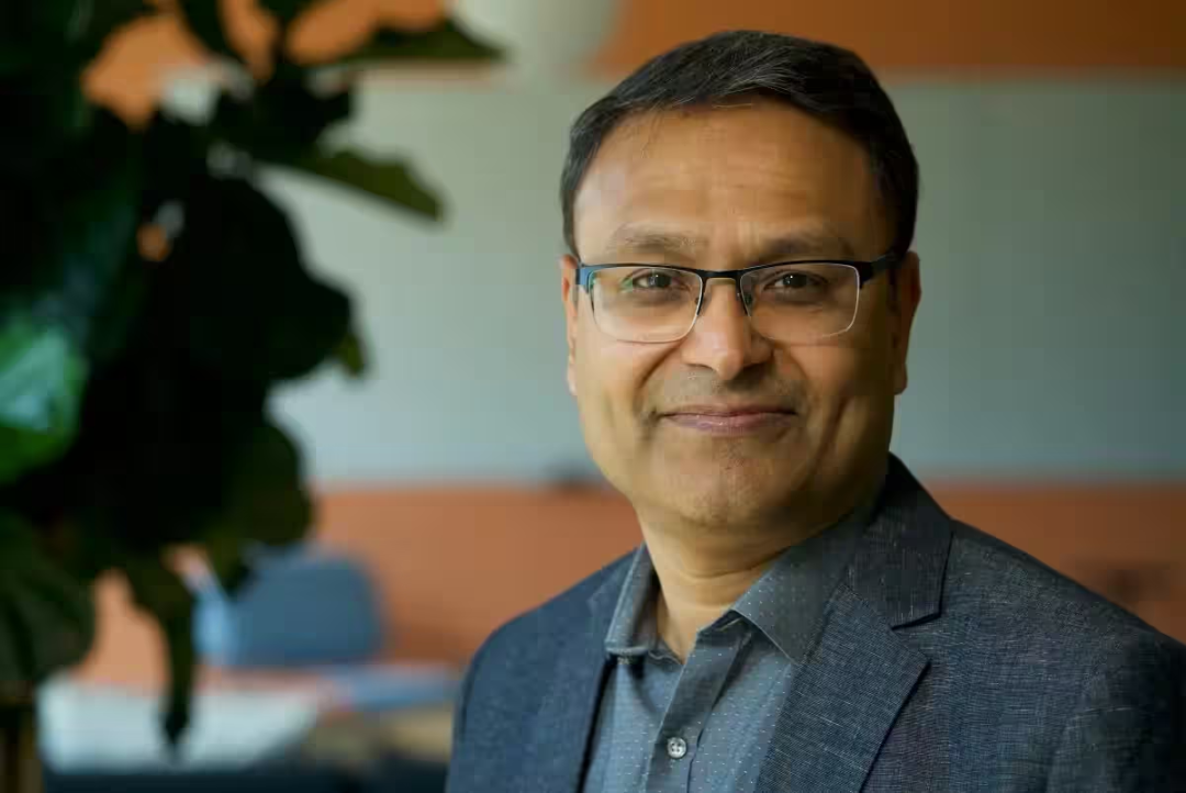 Prasad Kalyanaraman 半身肖像,深灰西装,黑框眼镜