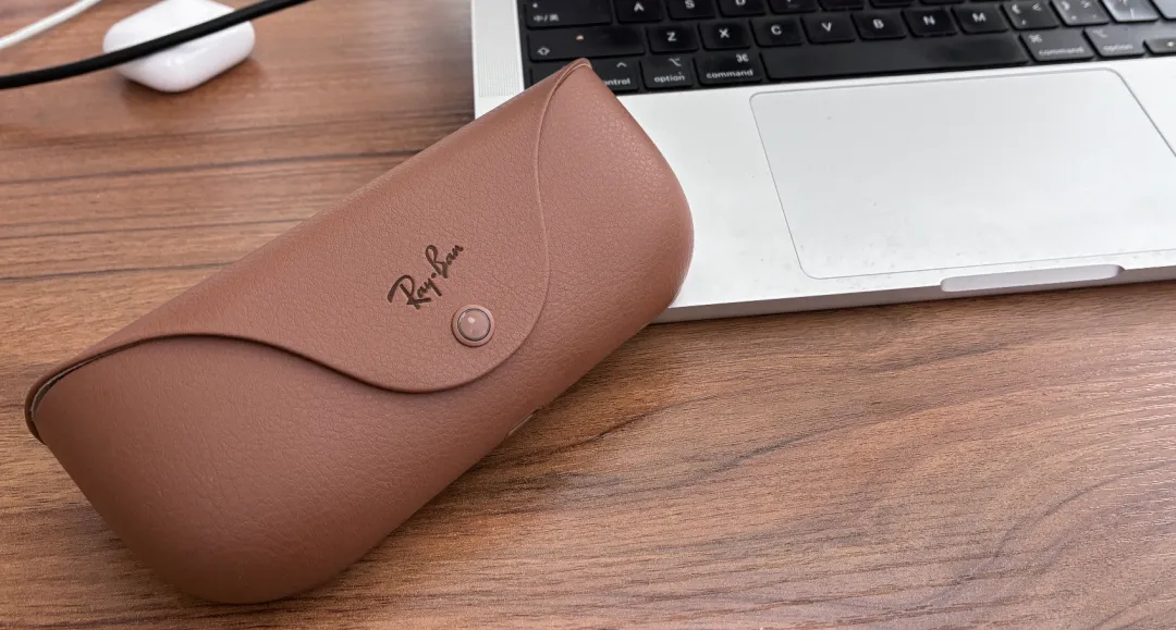 棕色皮革质感的Ray-Ban眼镜盒与笔记本电脑