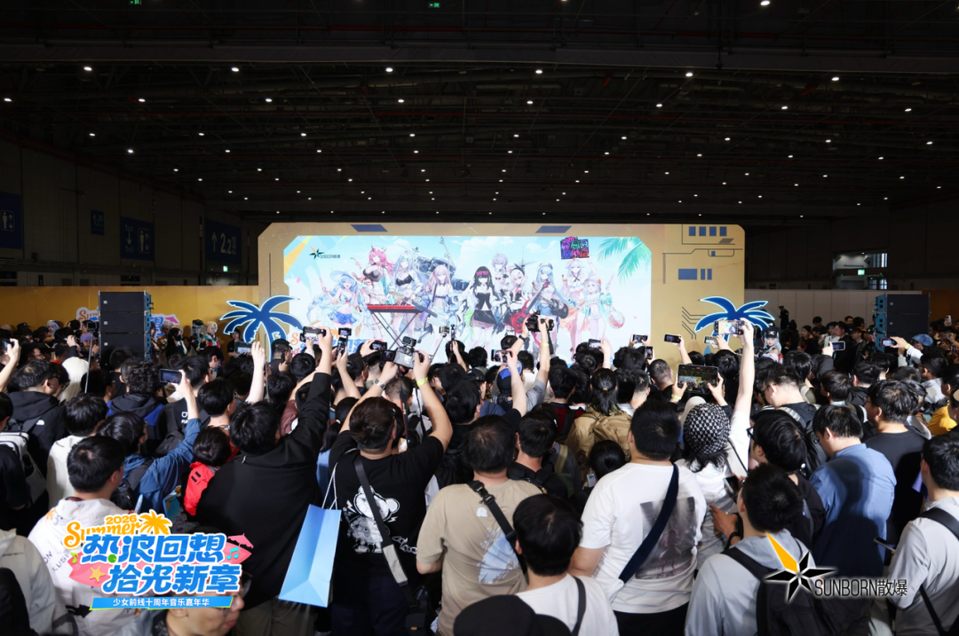 少女前线十周年音乐嘉年华主舞台，大量观众高举手机拍摄大型屏幕上的角色插画