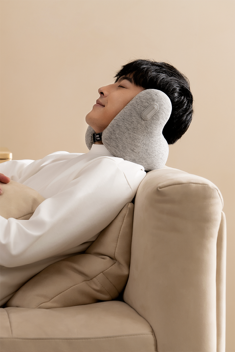 男性使用灰色颈枕休息
