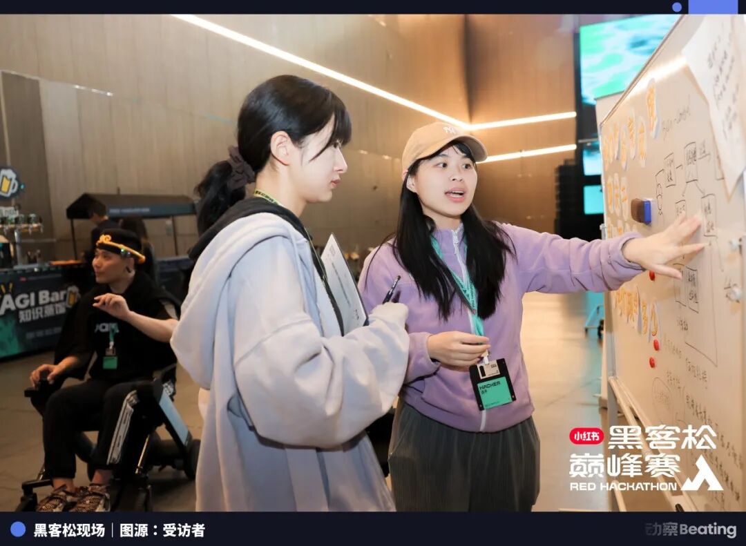 黑客松现场，女性在白板前交流