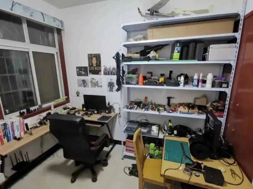 刘上的房间，墙上马斯克海报，桌上书籍与工具