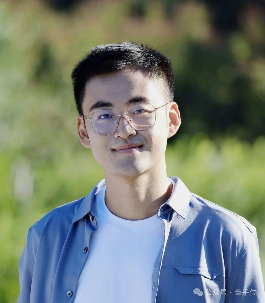 Sand.ai 创始人曹越,戴细框眼镜,浅蓝色衬衫,背景虚化户外