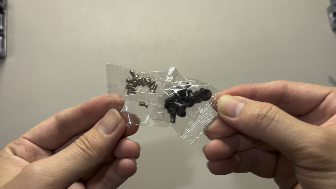 双手打开装有螺丝的透明袋