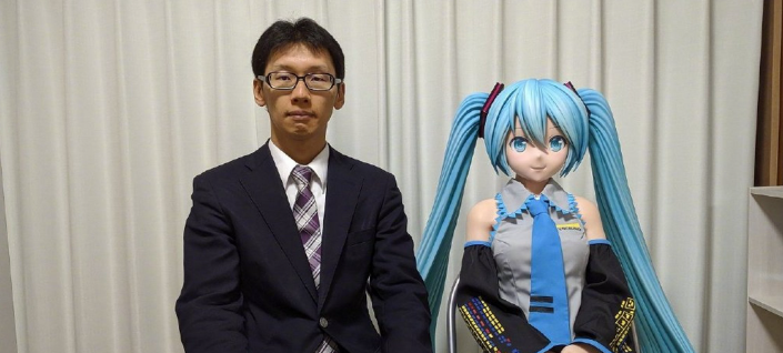 男性与初音未来手办并肩而坐