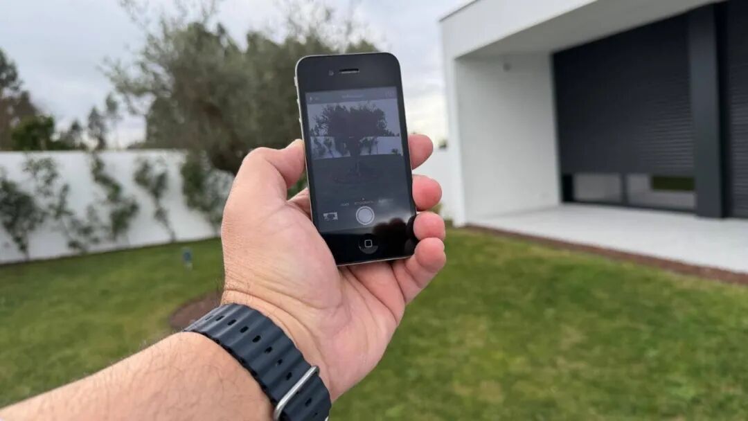 手持iPhone 4的户外场景