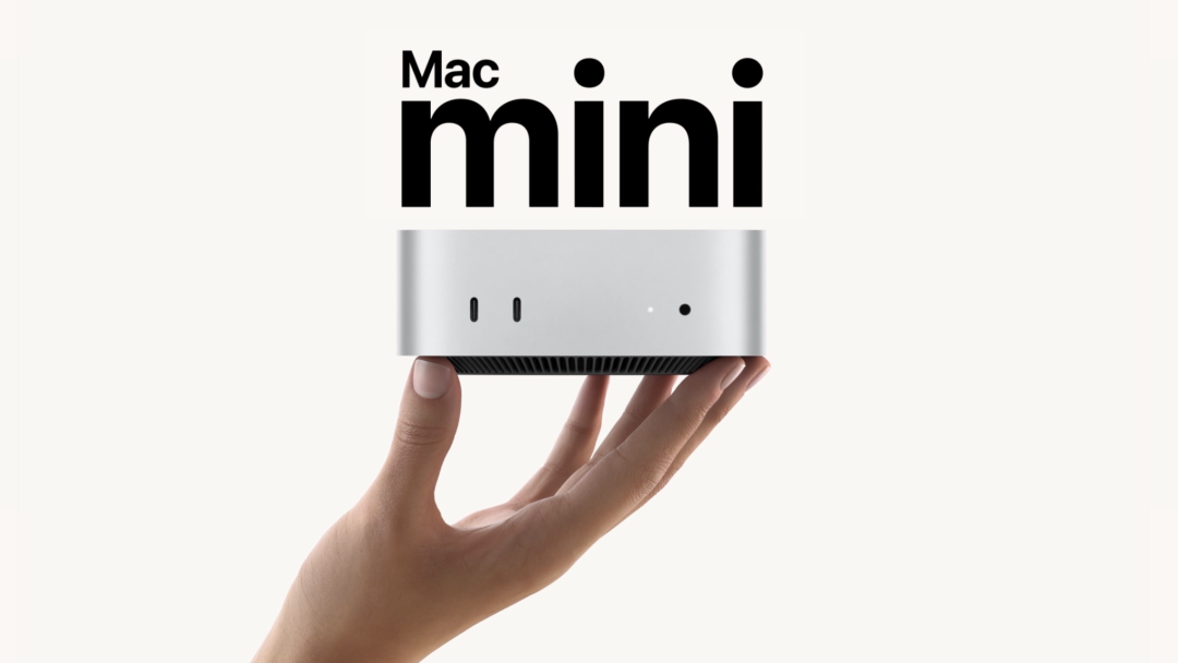 手持Mac mini银色主机，黑色Mac mini标识醒目