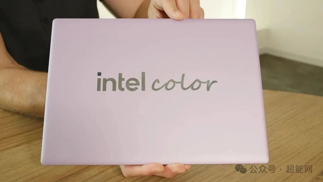 淡紫色金属笔记本正面手持展示,中央印有 intel color 字样