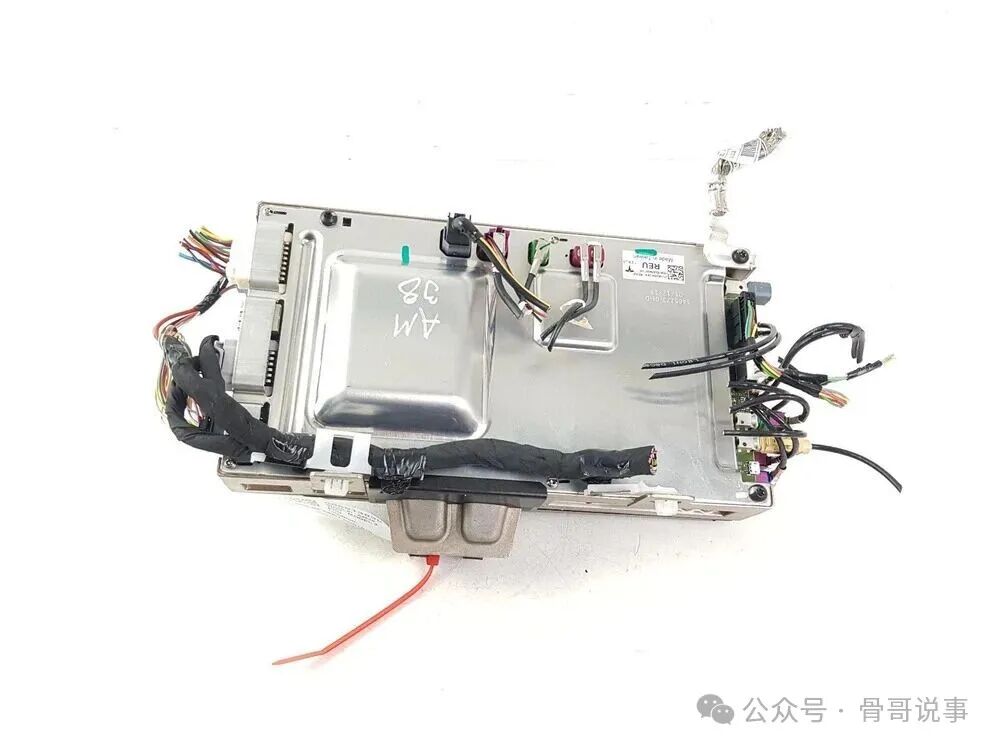 特斯拉Model 3 MCU和AP电脑，包裹在银灰色水冷金属外壳中，侧面连接多束彩色线束