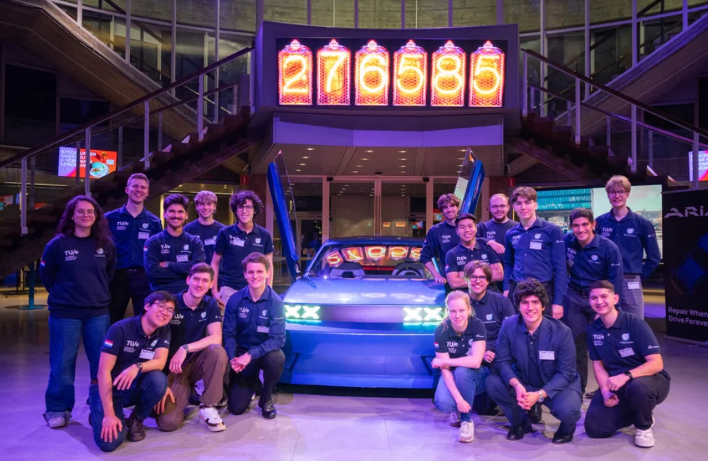 埃因霍温理工大学Ecomotive学生团队合影，背景为Aria EV原型车