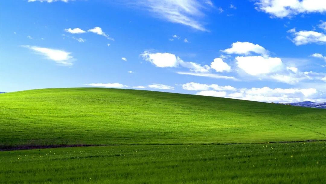 Windows XP经典Bliss蓝天白云绿色丘陵壁纸,象征消费级电脑生态