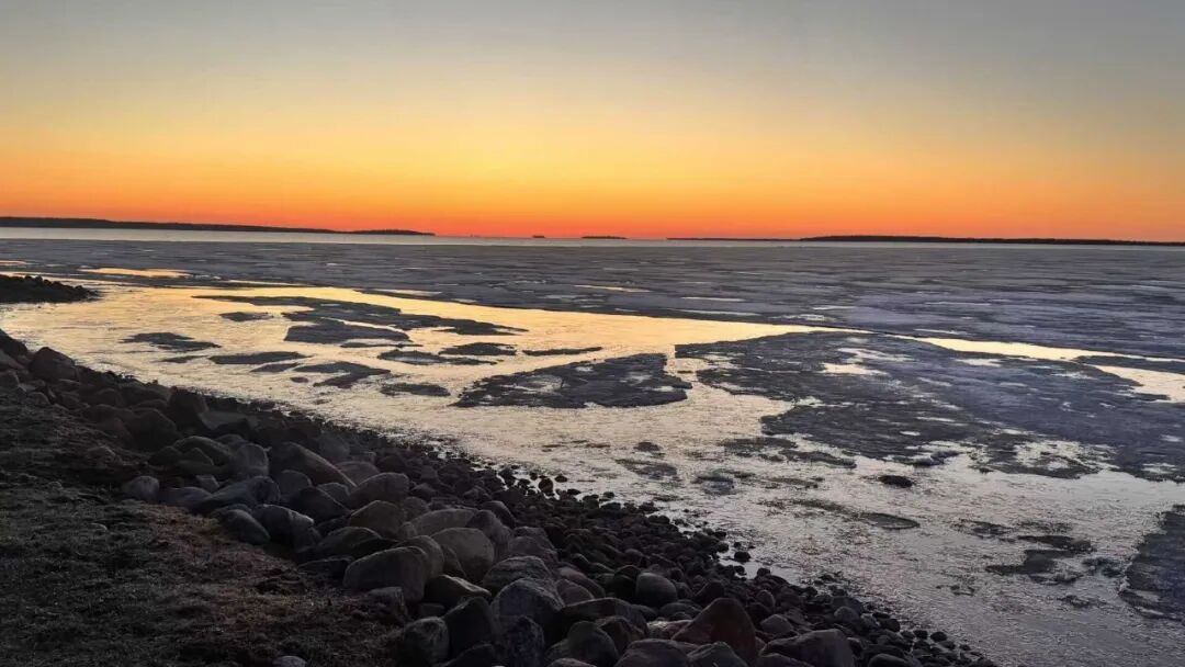 日落时分的冰封湖岸景色